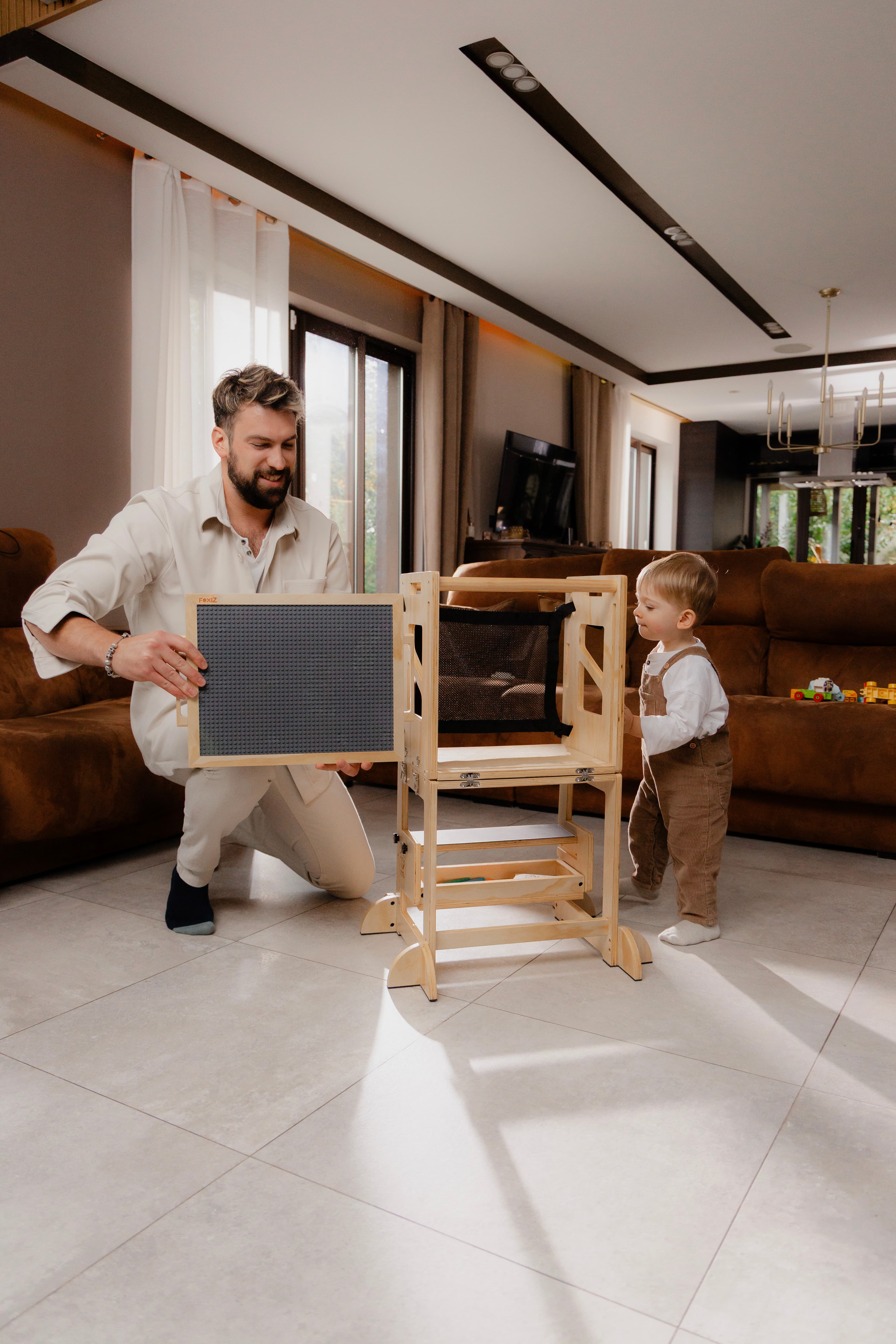 Father showing the Foxiz tower to his child in the living room